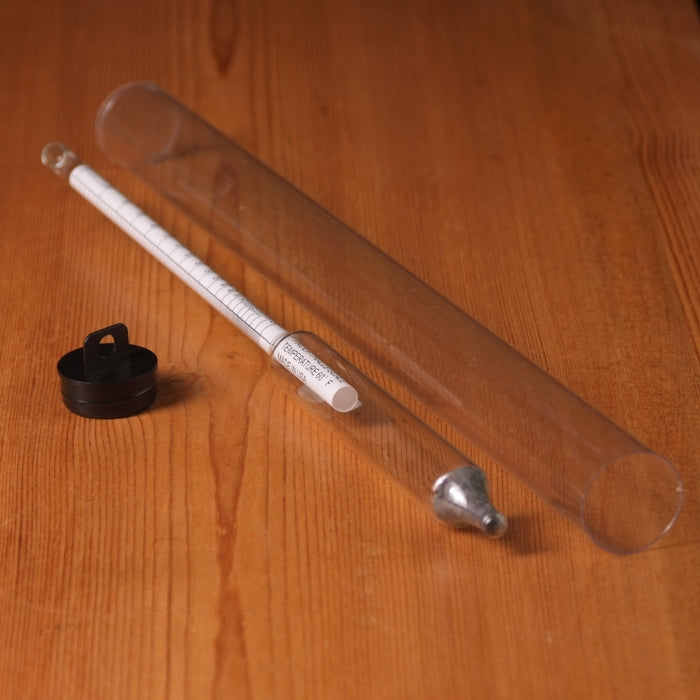 Hydrometer with a clear plastic tube on a wooden surface