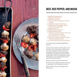 Beef, red pepper, and mushroom skewers on a tray with a recipe card on the side.