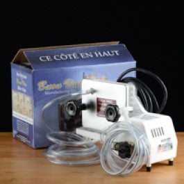Small filter machine with a box labeled 'Ce Cète En Haut' on a wooden surface.