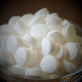 A glass bowl filled with tablets