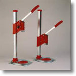 Two red and silver stand-up beer cappers on a gray background
