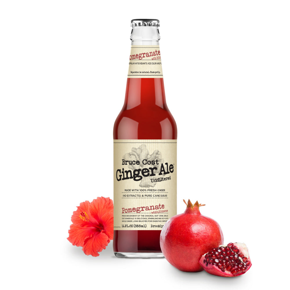 red liquid in a clear bottle with branding surrounded by pomegranates and a hibiscus flower on a white background