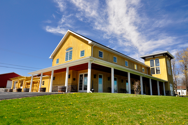 Yellow building with white columns on a grassy area under a blue sky