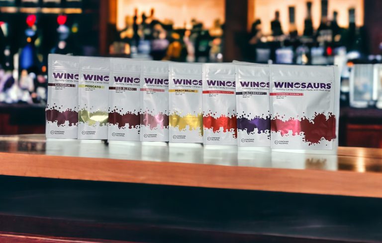Row of Winosaur wine packages on a bar counter with a blurred bar background