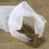 White mesh bag with dried herbs on a textured brown surface