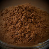 Close-up of brown powder in a glass container with a blurred background