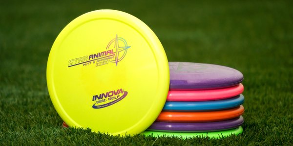 Stack of colorful disc golf discs on grass