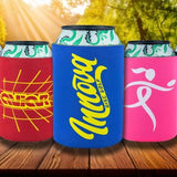 Assorted colorful can coolers with various designs on a wooden surface.