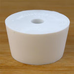 White rubber bottle stopper with hole on a wooden background