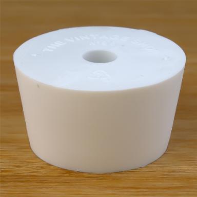 White rubber bottle stopper with hole on a wooden background