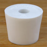 White rubber bottle stopper with hole on a wooden background