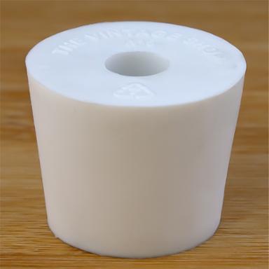 White rubber bottle stopper with hole on a wooden background