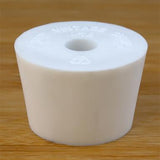 White rubber bottle stopper with hole on a wooden background