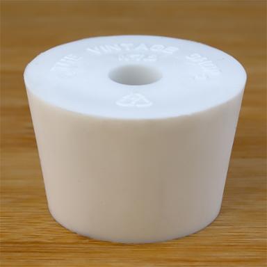 White rubber bottle stopper with hole on a wooden background