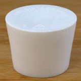 White rubber bottle stopper on a wooden background
