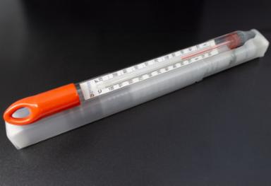 Bottle thermometer with orange handle on a black background