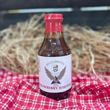 barbecue sauce bottle on red and white table cloth with straw hay background