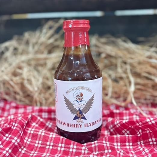 barbecue sauce bottle on red and white table cloth with straw hay background