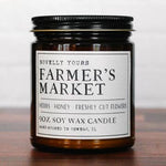 Candle jar labeled 'Farmer's Market' on a wooden surface with a white background